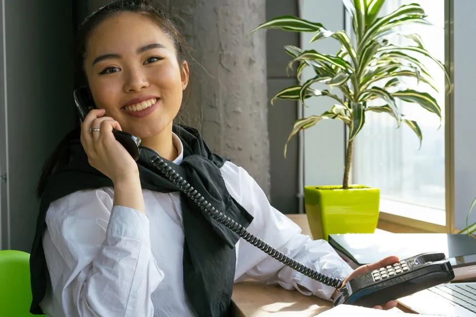 a carer on the phone arranging a home visit in a bright office